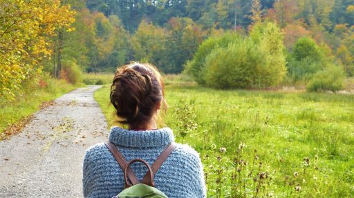 A photo of a woman walking down a country path
