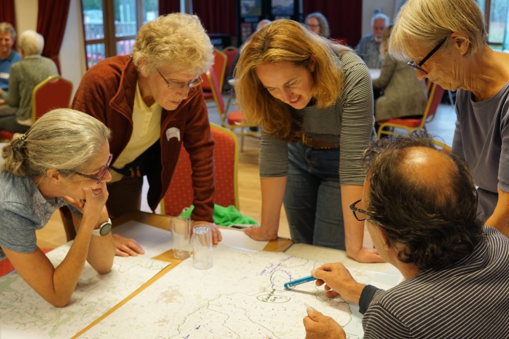 A group of people discussing and annotating a river catchment map