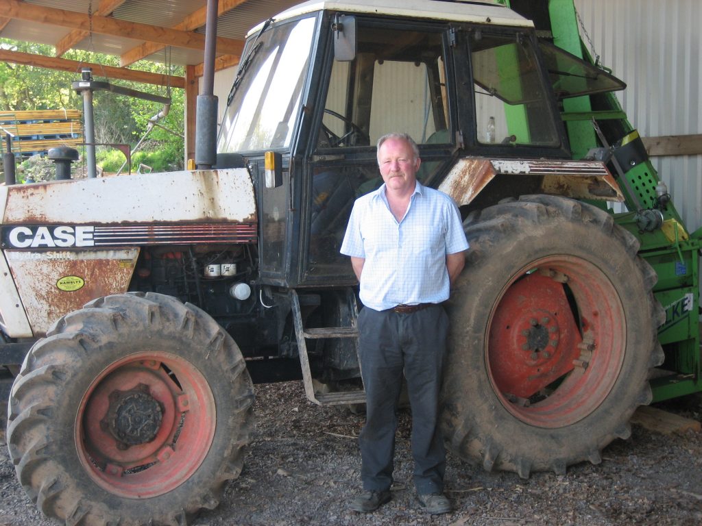 John Greenshields standing in front of a tractor