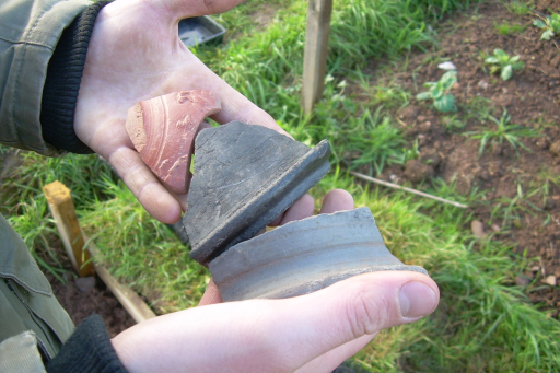 Someone holding clay pot fragments